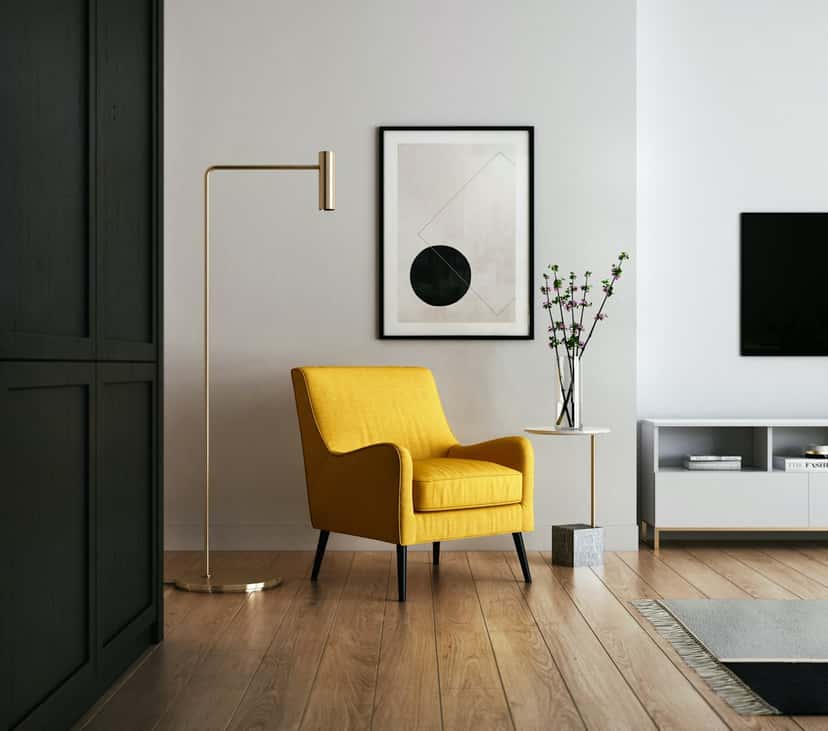 Wall art scaled to a reading corner with a yellow armchair