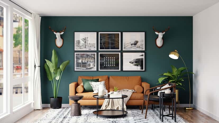 A symmetric grid of six framed prints hanging above an orange sofa on a dark teal wall