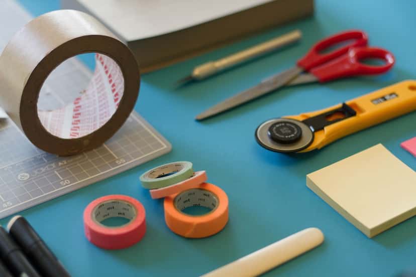 Tape, scissors, and paper templates for planning a gallery wall layout